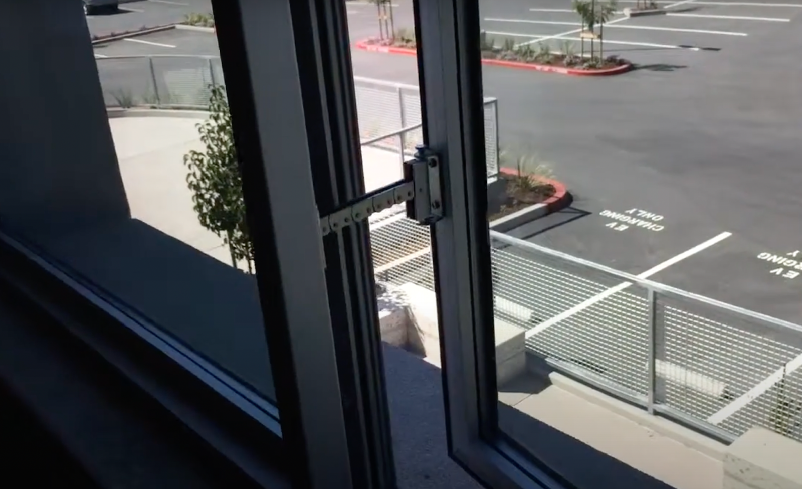 This office building room has a window overlooking a parking lot.