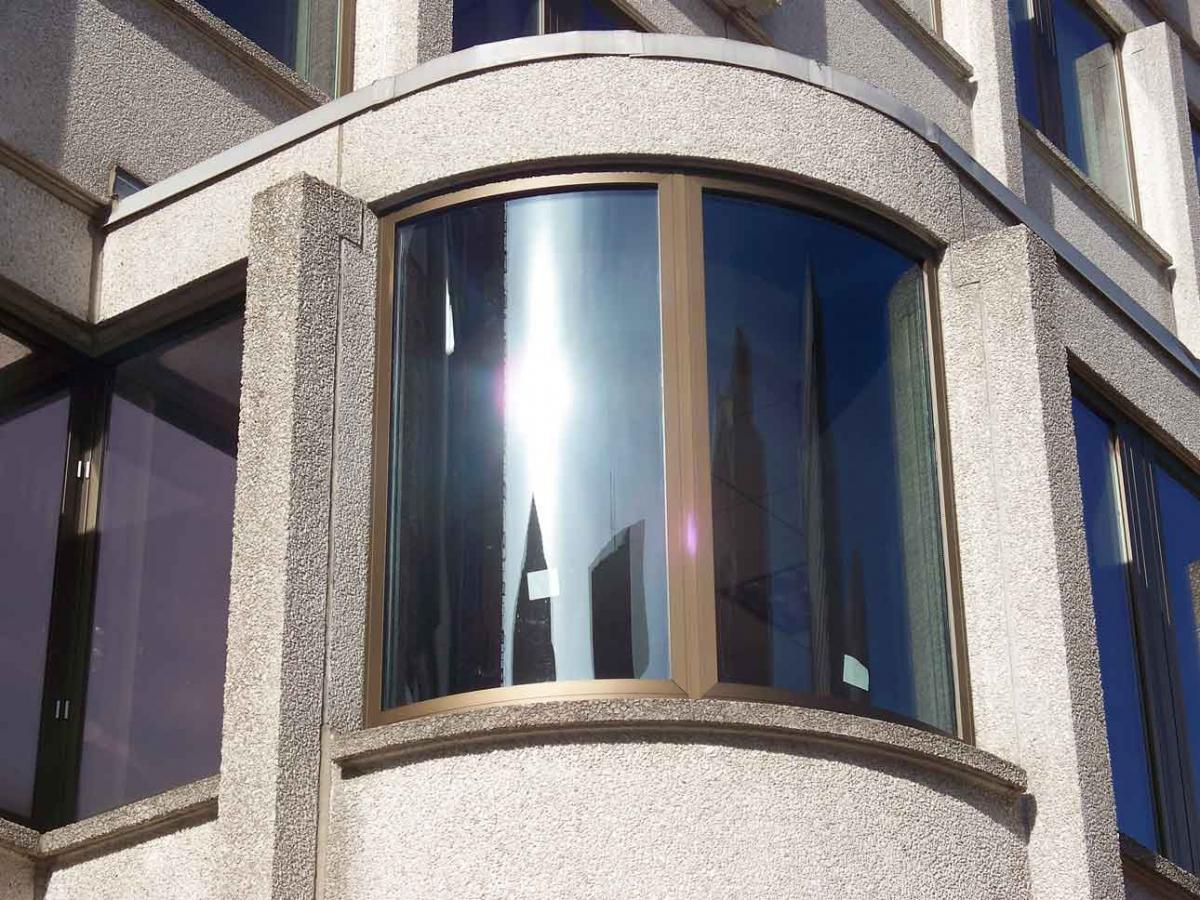 An up-close image of a curved window on the John F. Kennedy Federal Building.