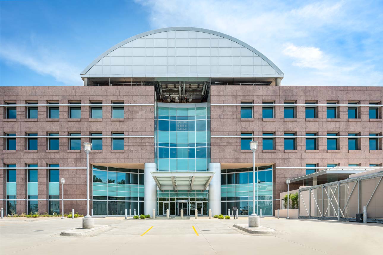 Front view of a building with a grand entrance and a significant glass window, highlighting its architectural elegance.