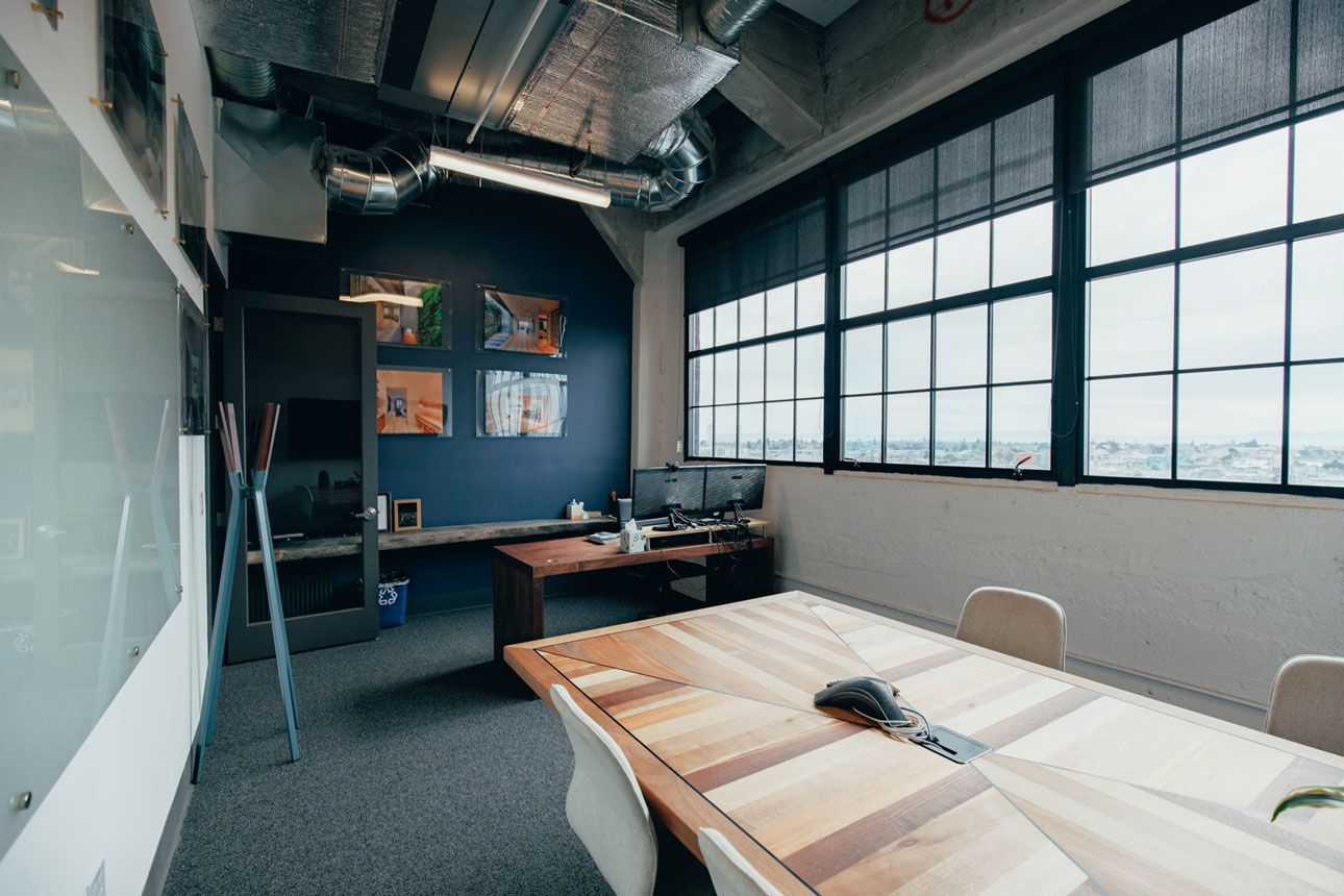 Interior building office room with desk and chairs and large windows.