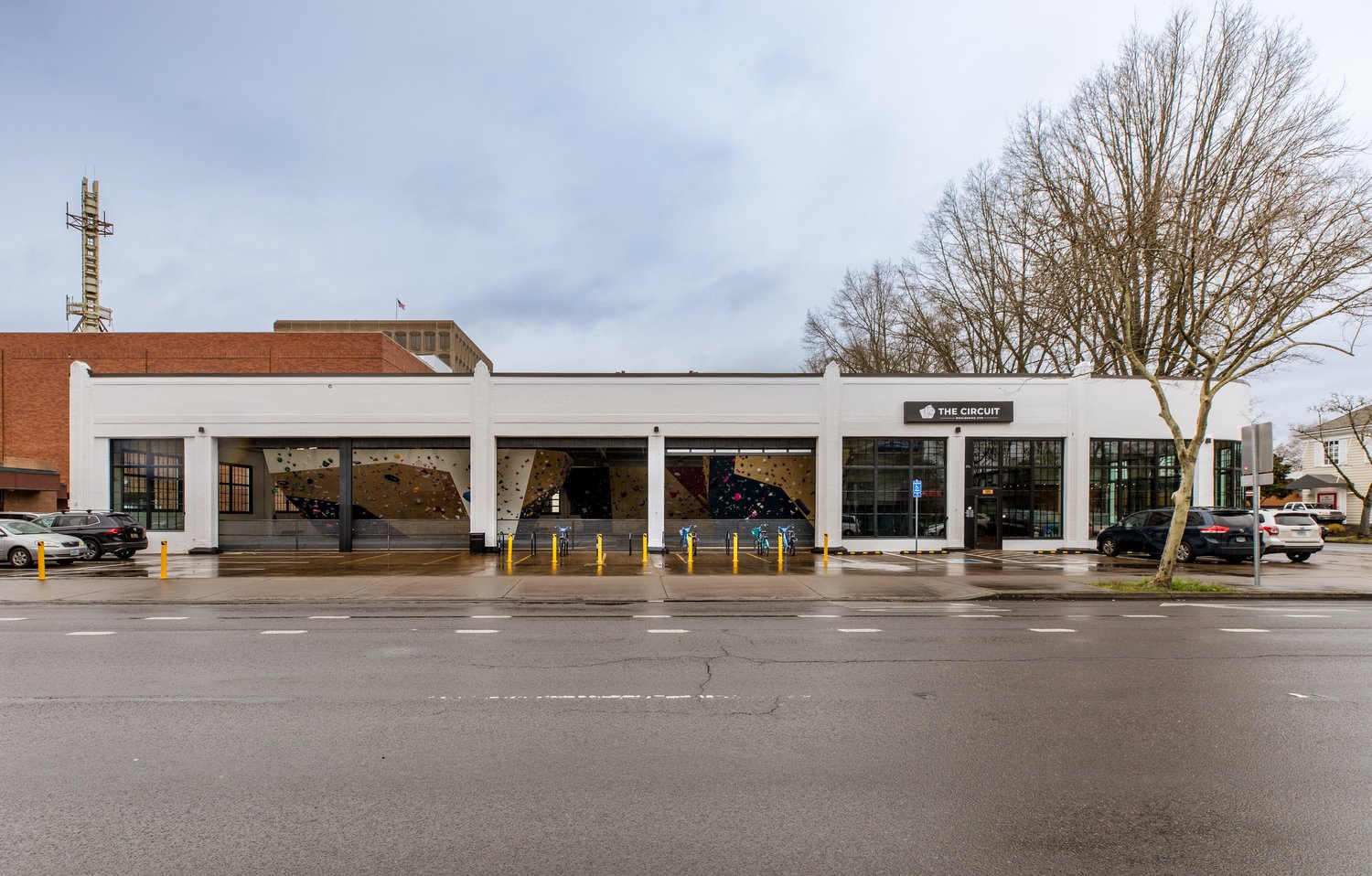 Winco's 3250 Series Steel Replica windows feature dark bronze trim and multiple grids, making them a striking element against the cream-colored walls of both the exterior and interior at The Circuit Gym.