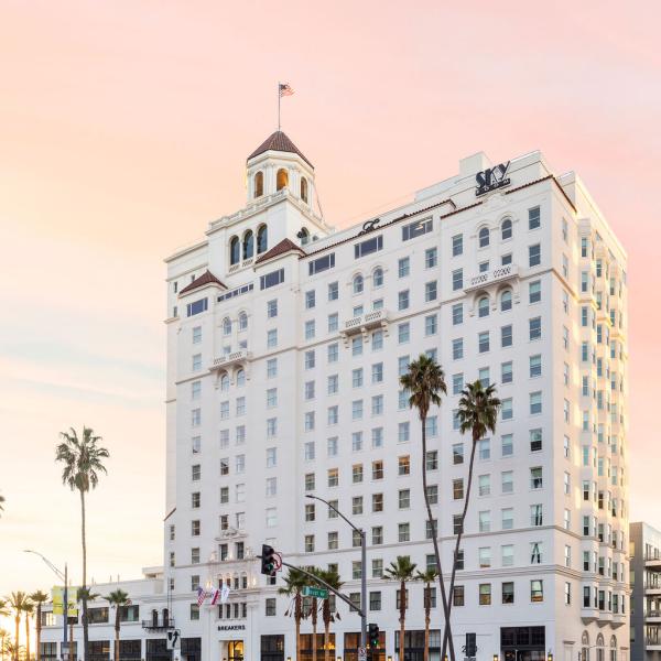 Exterior side view of historic building with palm trees in front 