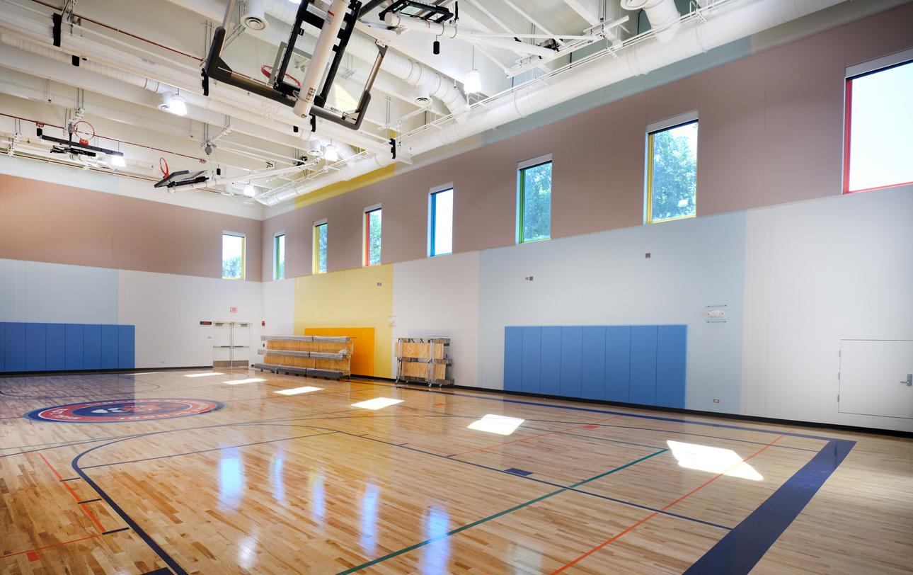Lincoln Elementary School utilizing Winco’s FEMA 361 – ICC 500 tornado resistant windows in the gym, used as Safe Rooms for storms. A large interior gym with tornado resistant windows against a clear blue sky, showcasing a school’s safe room.