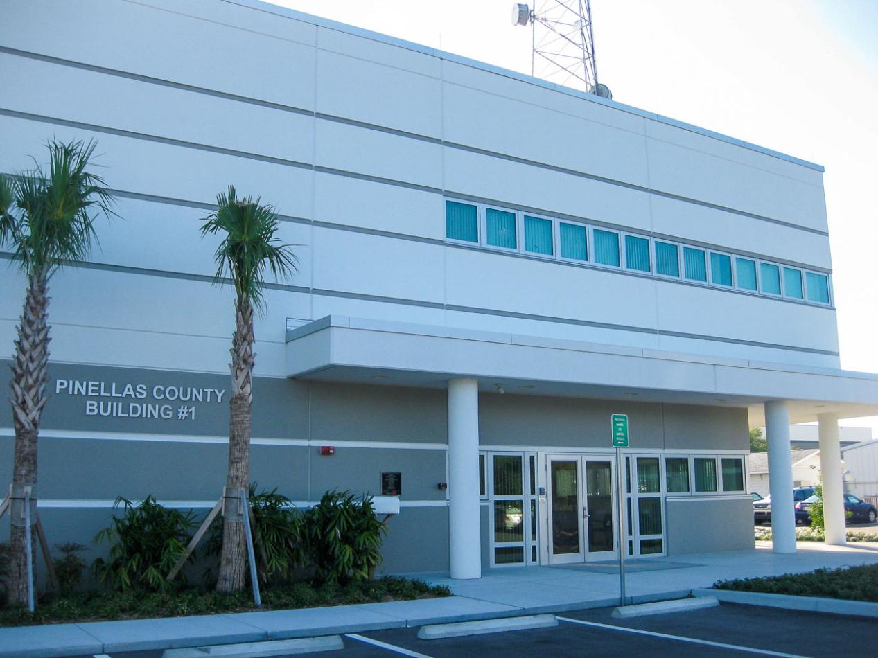 The Public Works Emergency Responders Building (PWERB) is a 2-story facility that is LEED Gold Certified and includes Winco tornado-rated windows. A tall commercial building with numerous windows against a clear blue sky. The architectural facade showcases a modern design, emphasizing the glass and structure of the property.