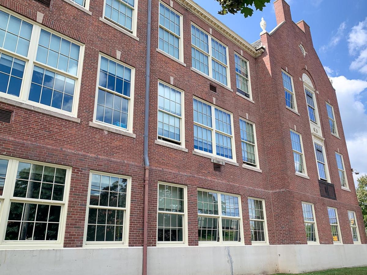 A brick building featuring a window, showcasing red brickwork and outdoor surroundings.