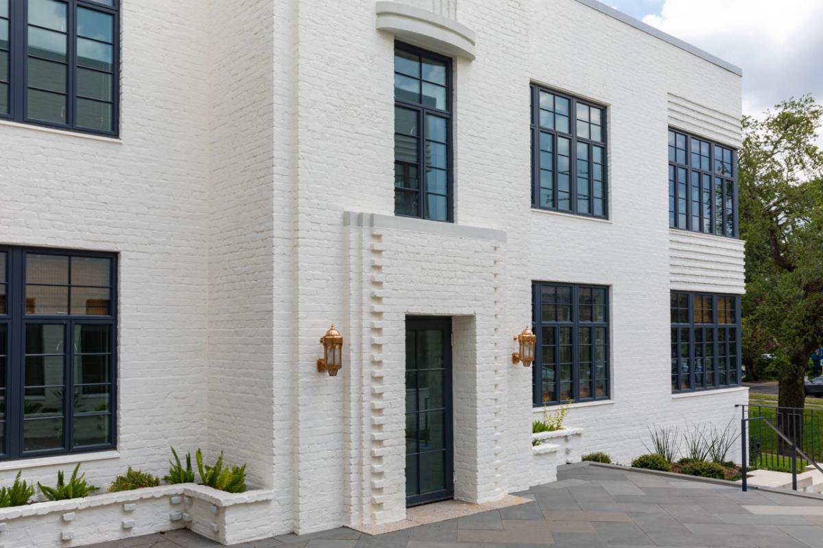 Farnsworth Apartments using Winco's Hurricane Resistant 3250 Steel Replica windows and NC-82 doors. A white building with windows and a courtyard, showcasing WINCO’s NC82 Terrace Doors that meet hurricane safety standards.