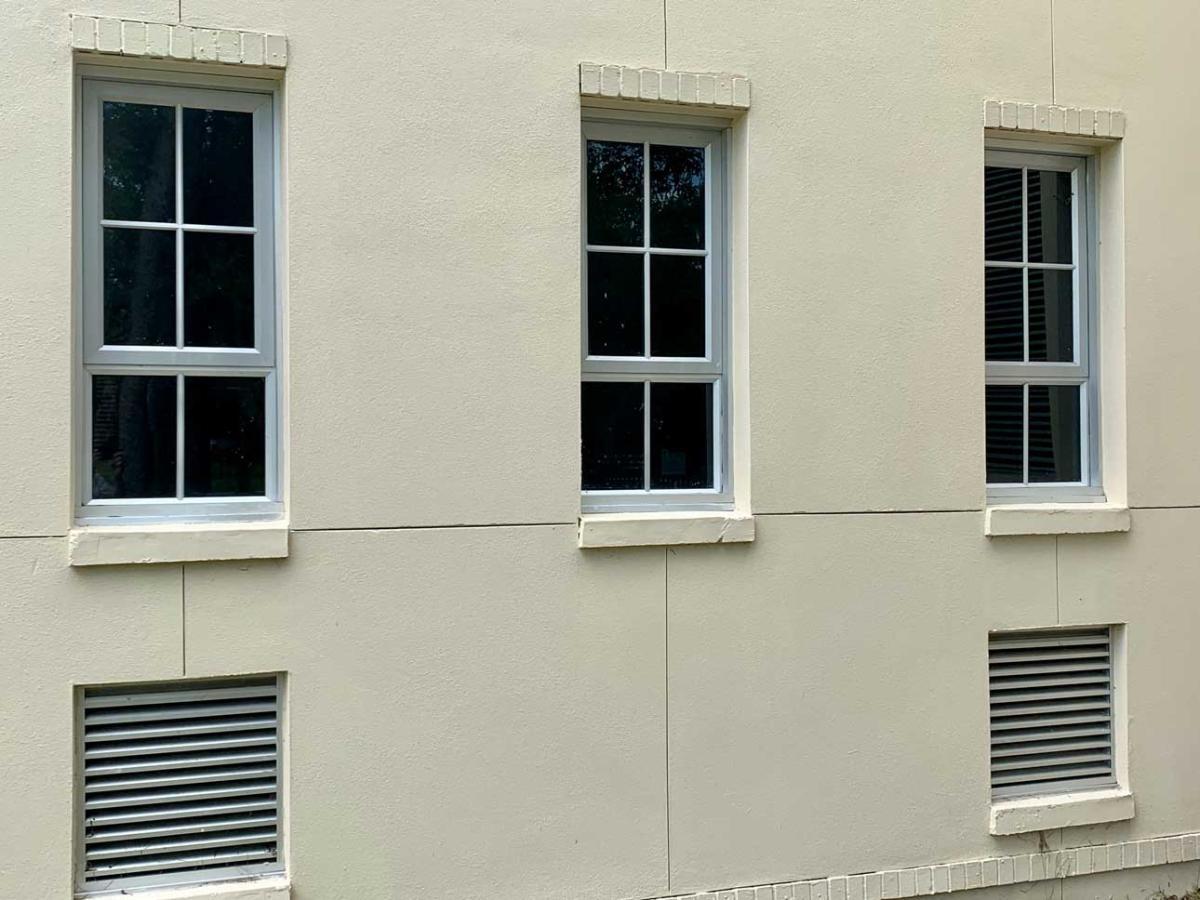 Winco's 1150S series windows fitted with hurricane laminated E-missile glass at the Louisiana Pump Station. Exterior of building with windows and trees in background
