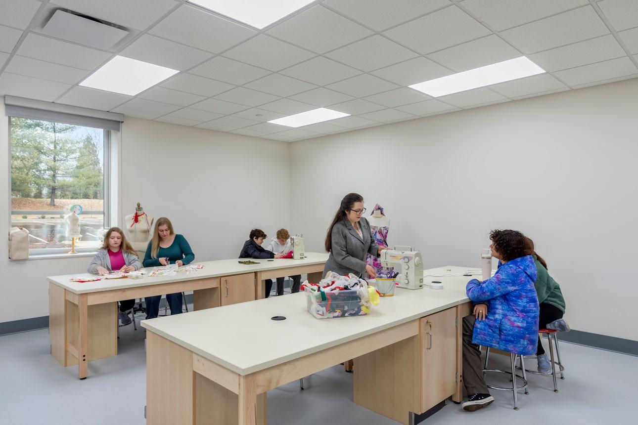 Winco supplied its FEMA 361 - ICC 500 window series, featuring a sturdy frame and impact-resistant laminated glass, for Kirkwood High School's storm shelter.  Interior classroom with desks and students with a FEMA window in the background.