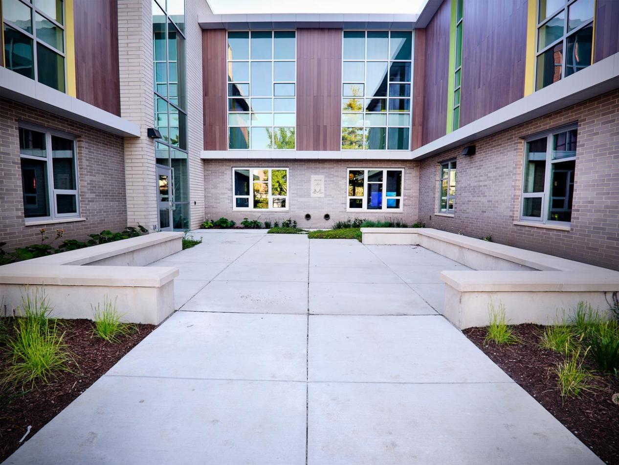  A courtyard featuring a bench and a window, showcasing Winco's 3325 Zero Sightline windows at Lincoln Elementary School.