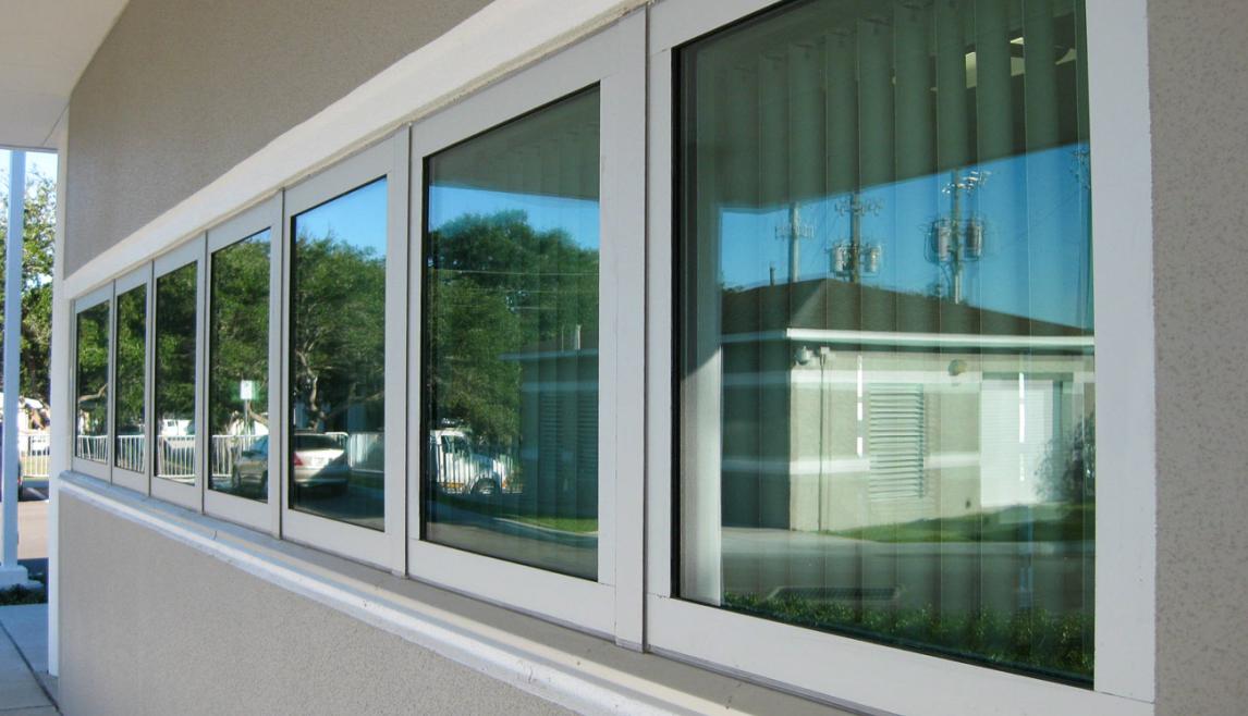The Public Works Emergency Responders Building (PWERB) is a two-level building that holds a LEED Gold Certification and features Winco tornado-rated windows. Close-up of a building, featuring a tornado resistant window. The setting includes indoor and outdoor elements, highlighting the fixture attached to the wall of a building.
