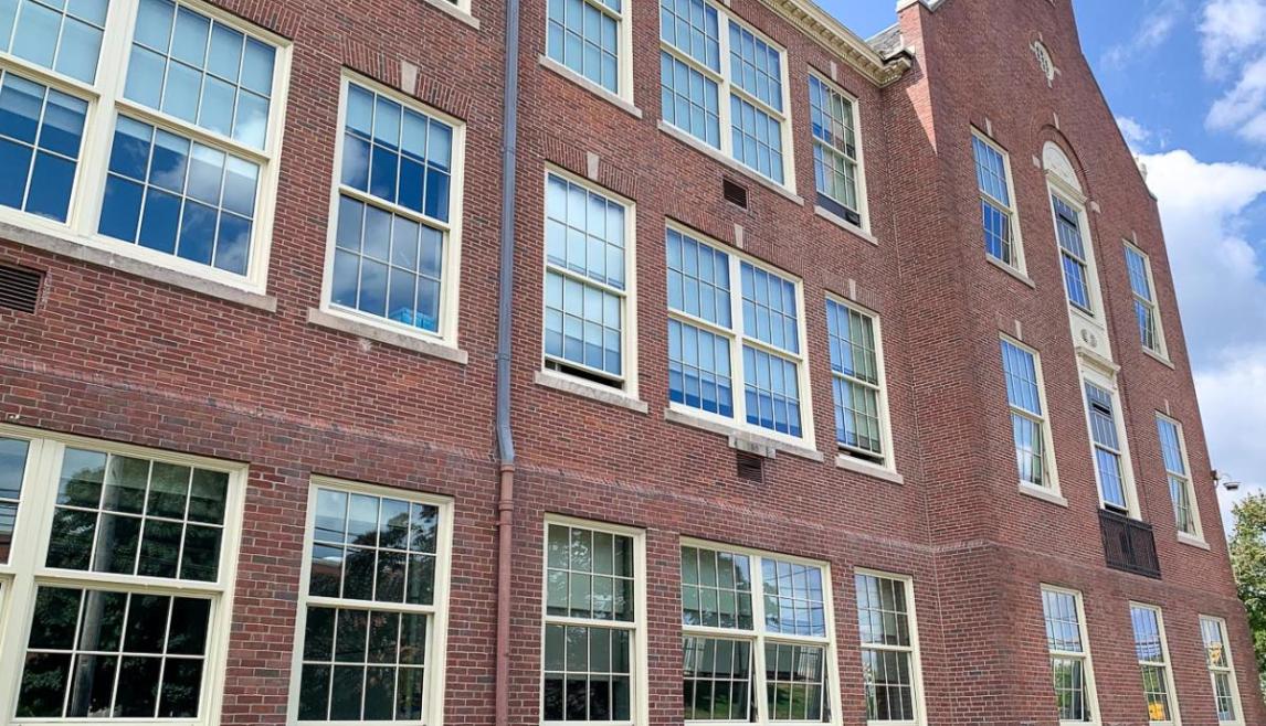 A brick building featuring a window, showcasing red brickwork and outdoor surroundings.