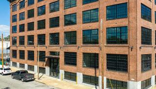 Historic brick building with large black steel replica windows