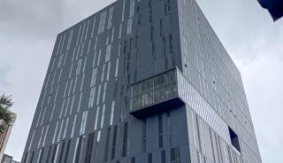 Corner view of a large black building with a curtain wall system and zero sightline operable windows.