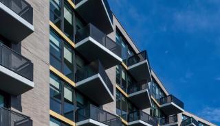 Apartment complex in Washington, D.C. featuring parked cars and an apartment complex with windows.