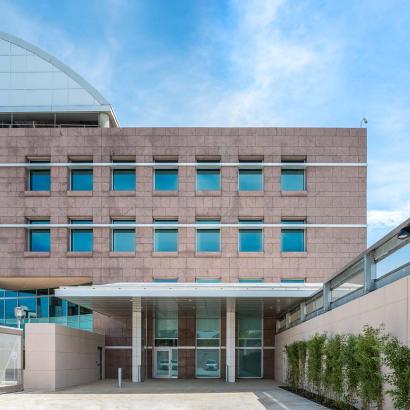 Main entrance of a hospital featuring stone architecture and Human Impact Resistant Windows for patient care rooms.